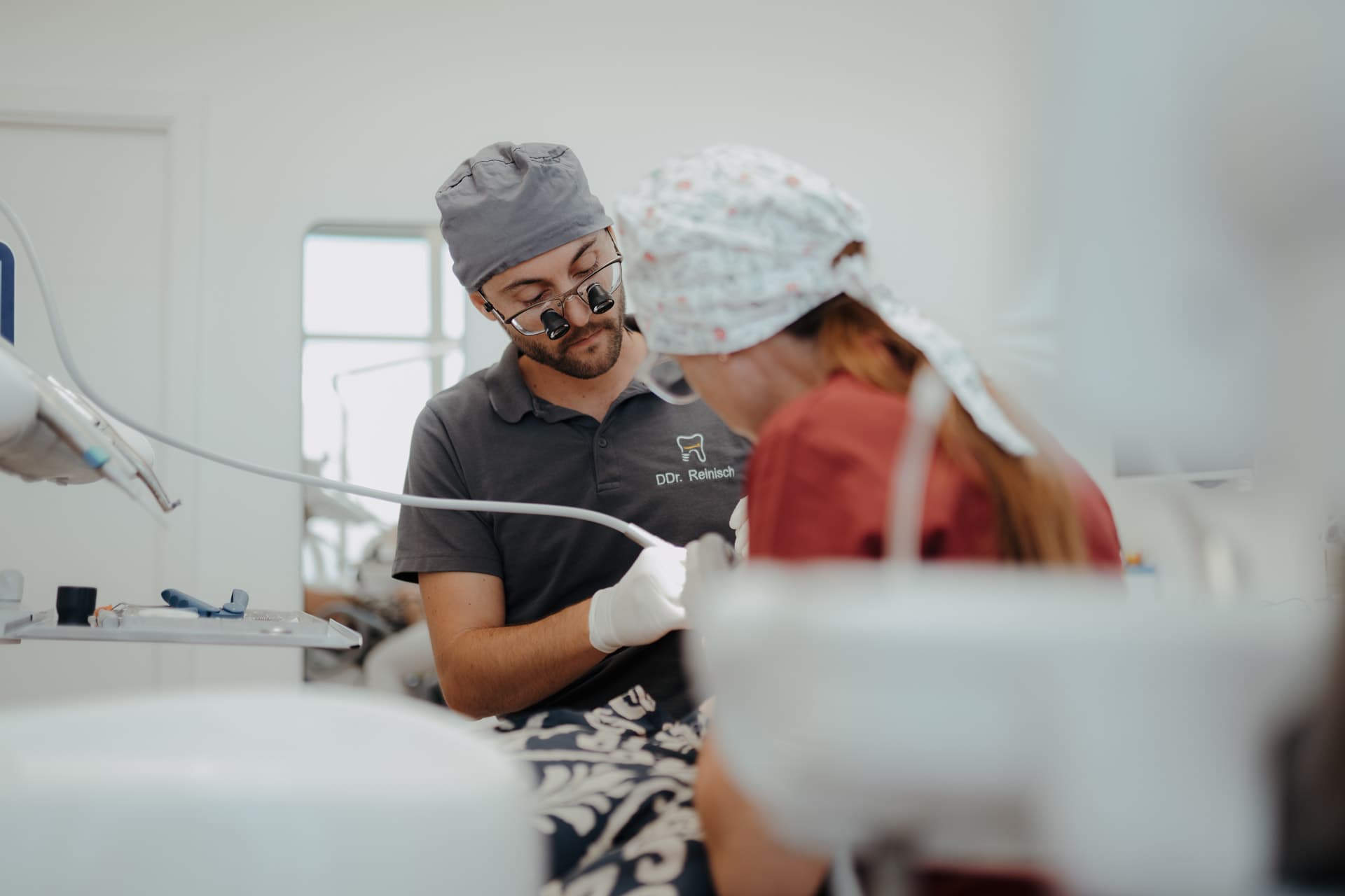 DDr. Manuel Reinisch und seine Assistentin bei der Behandlung in der Ordination dentalReinisch
