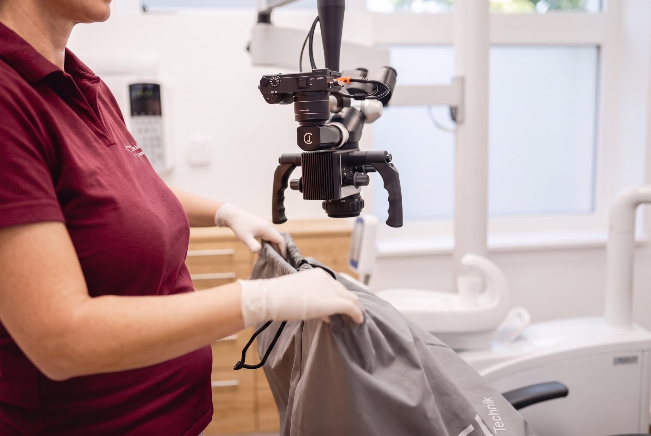 Mitarbeiterin bereitet das Operationsmikroskop in der Ordination dentalReinisch vor