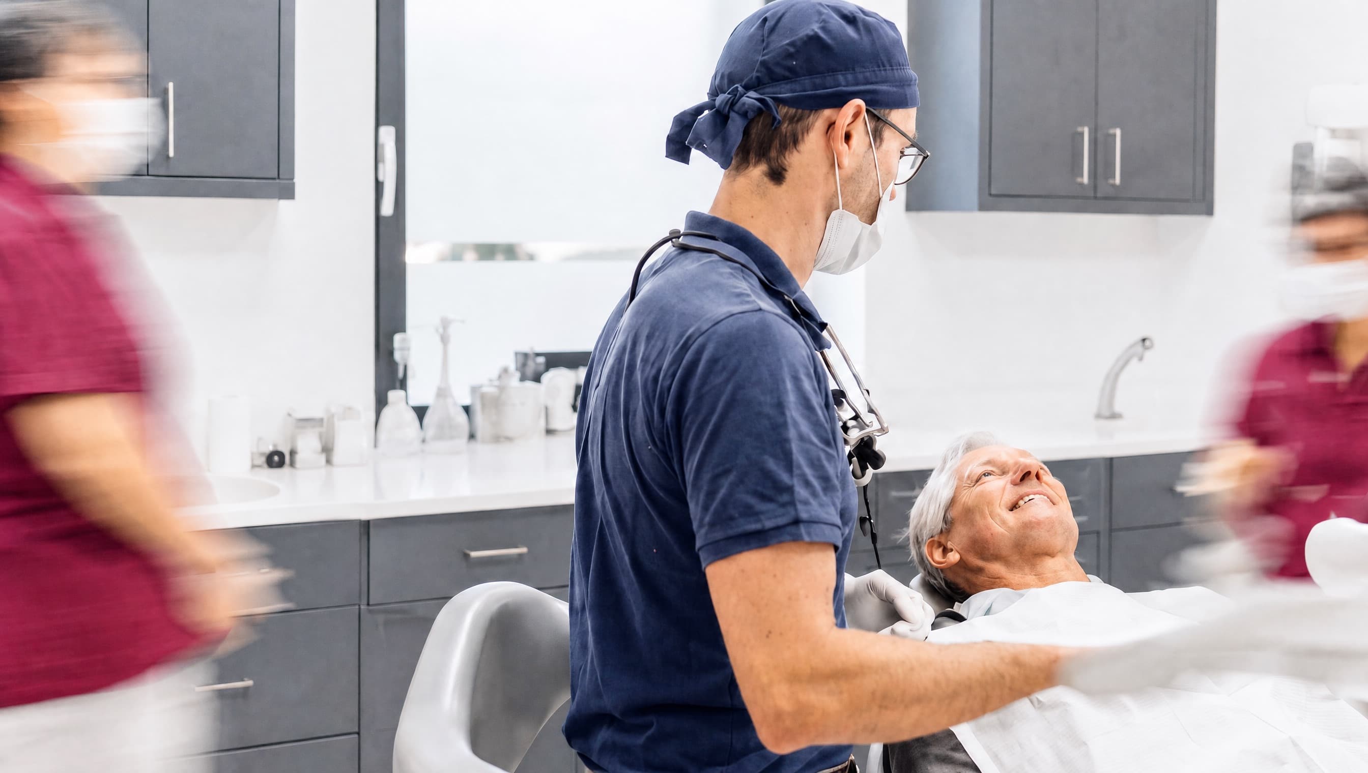 Behandler am Behandlungsstuhl mit einem Patienten in der Ordination dentalReinisch